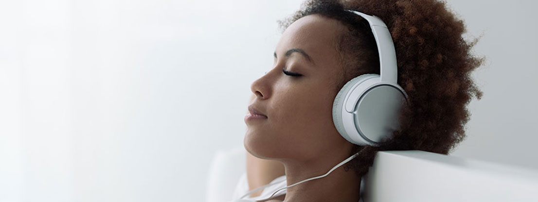 Frau entspannt mit binauralen Beats