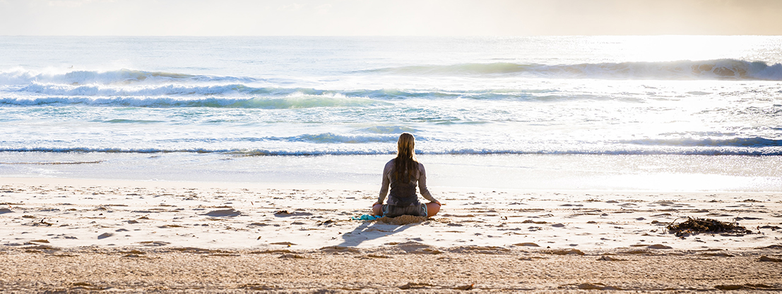 Woman meditating on beach