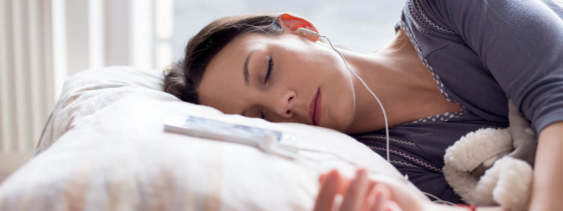 Woman sleeping with headphones, relaxation music