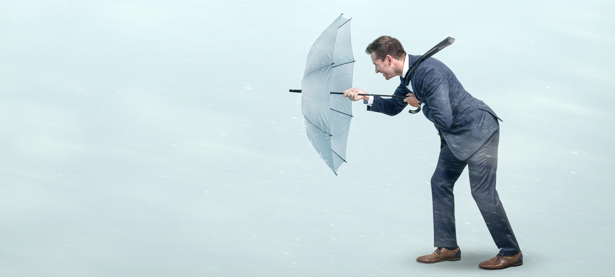 Resilienz - Mann mit Regenschirm leistet widerstand gegen den Sturm