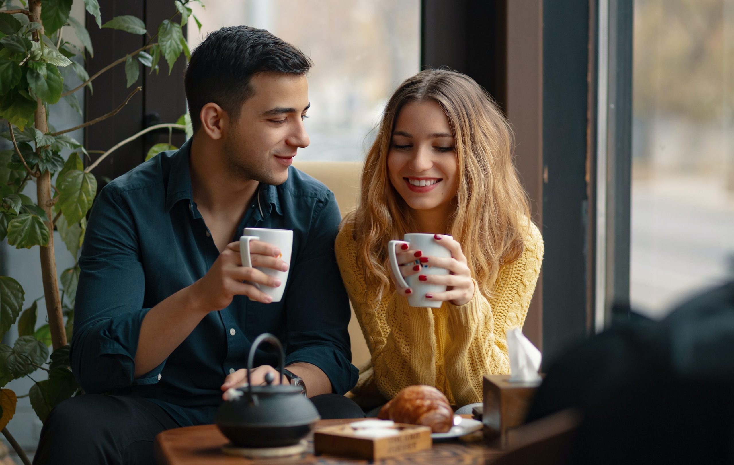 Schöne Momente - Junger Mann und Dame trinken einen Kaffee bei einem Date