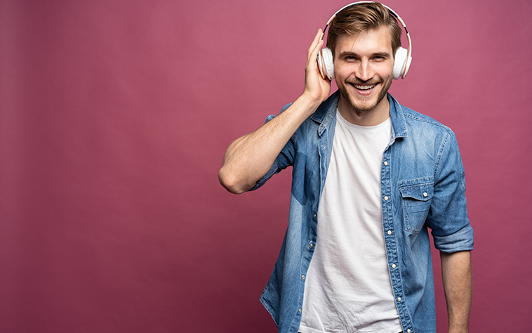Junger Mann mit Kopfhörern, roter Hintergrund
