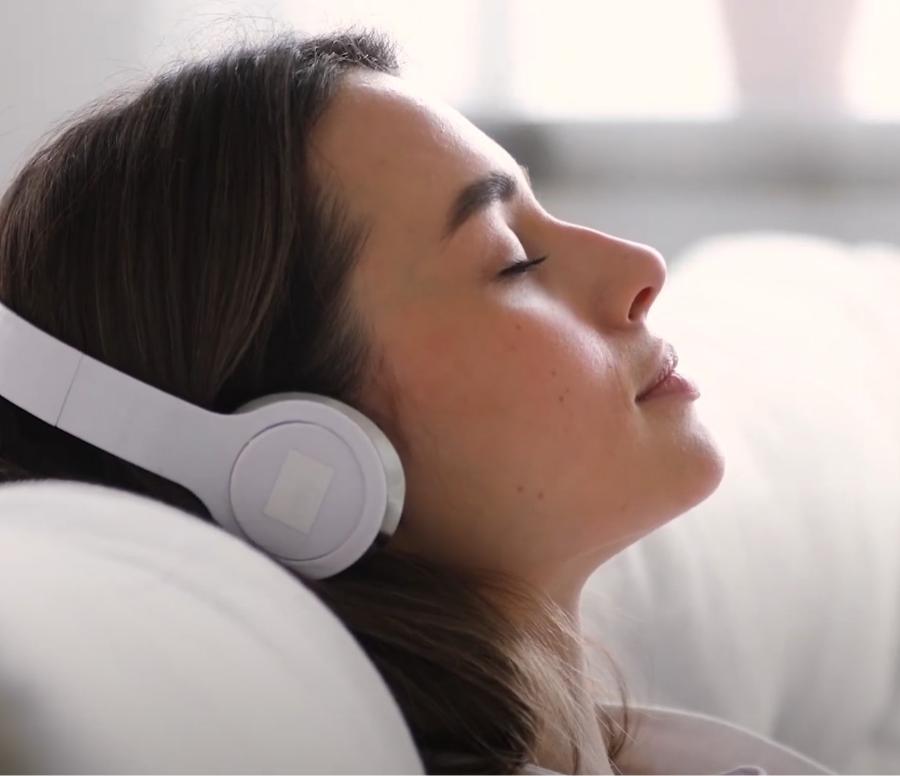 Frau mit Kopfhörern hört entspannt Musik