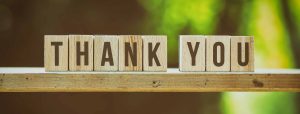 Die Wörter „Thank You“ wurden mit Buchstabensteinen aus Holz gelegt.
