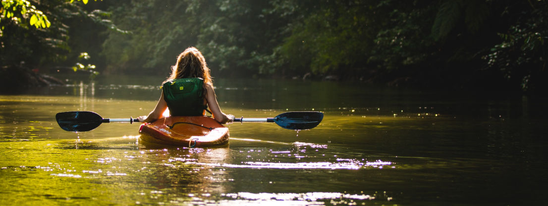 Person im Kayak, die sich den Fluss hinabtreiben lässt. Voller Vertrauen in den Fluss des Lebens, wie es ist, wenn man Urvertrauen hat.