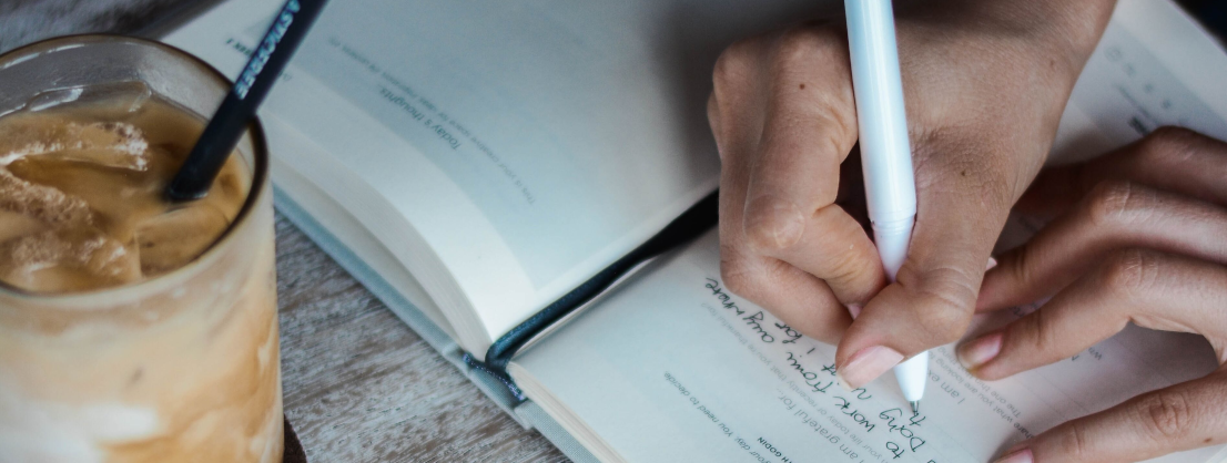 schreibende Hand, die Tagebuch führt. Das niederschreiben der eigenen Gedanken kann helfen, Grübeln zu stoppen