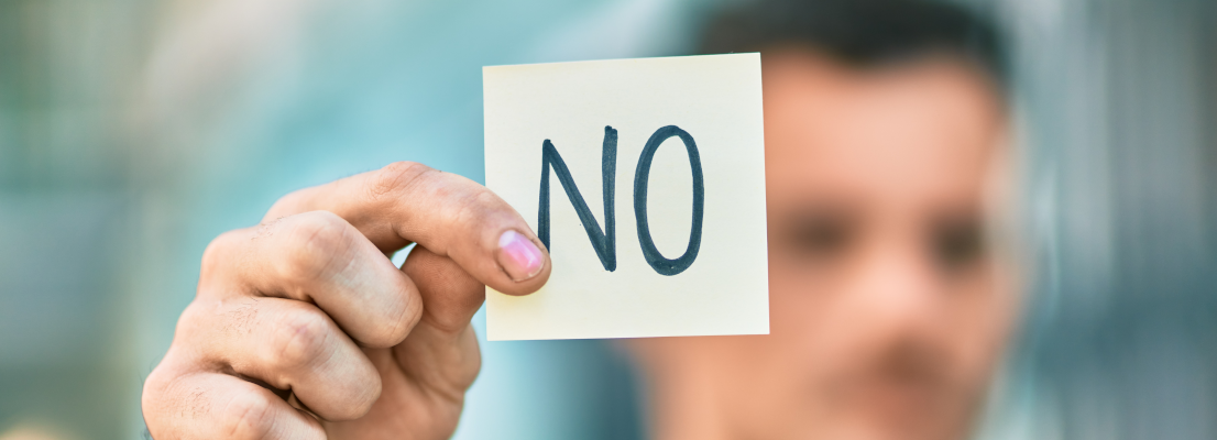Person hält Zettel mit "No" hoch, Nein Sagen für mehr intrinsische Motivation