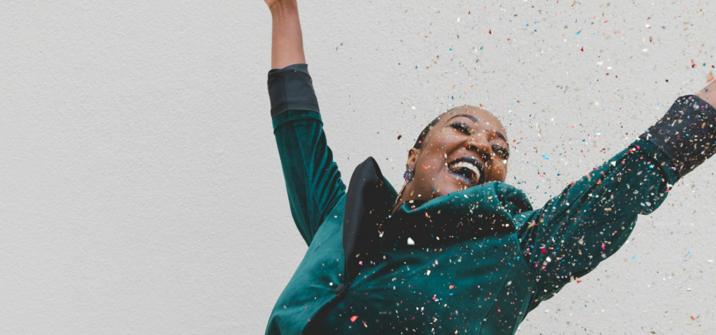 Frau wirft die Arme in die Luft und feiert den World Mental Health Day